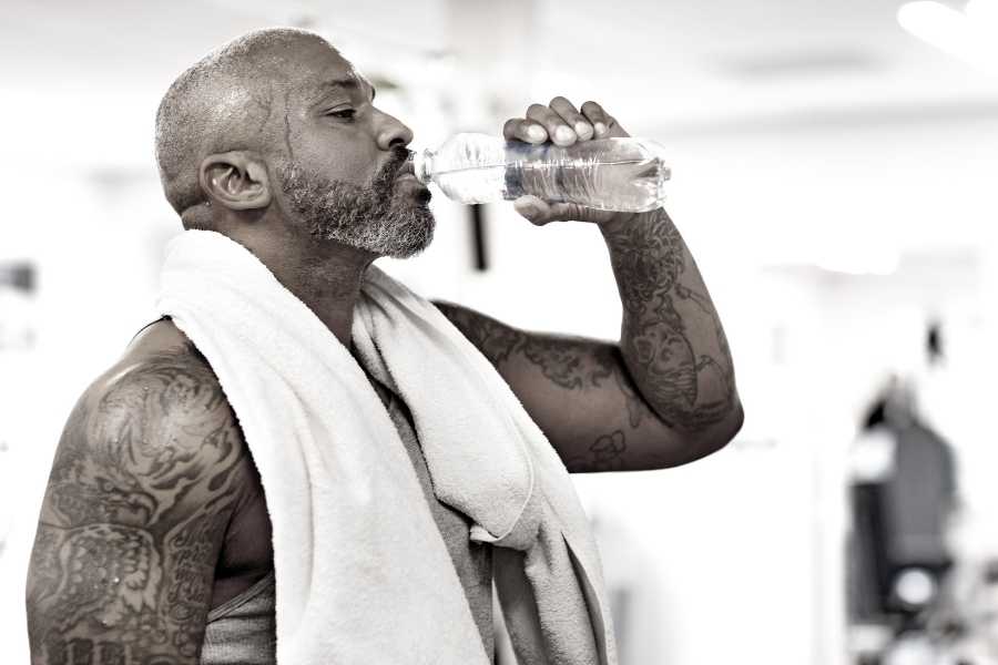 Black man drinking bottle of water